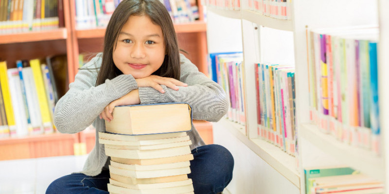 Ilustrasi anak dan tumpukan buku di perpustakaan. (Freepik/jcomp)