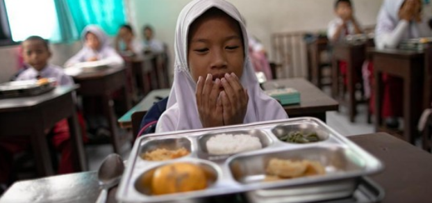 Seorang siswa berdoa sebelum menyantap sajian Makan Bergizi Gratis (MBG) yang dimulai hari ini (6/1)/CNN